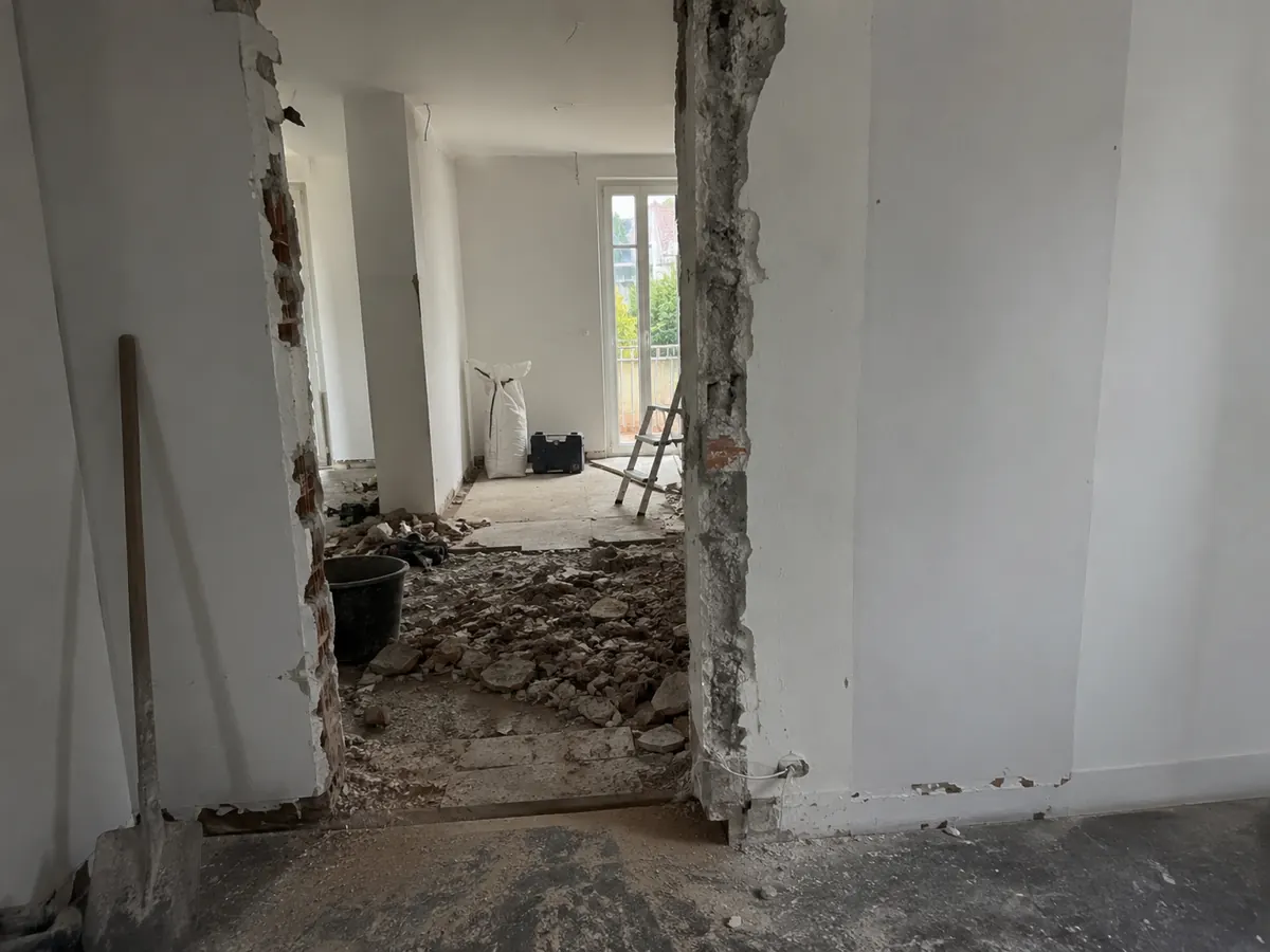 Geöffneter Wanddurchbruch mit Bauschutt während Abriss- und Rückbauarbeiten
