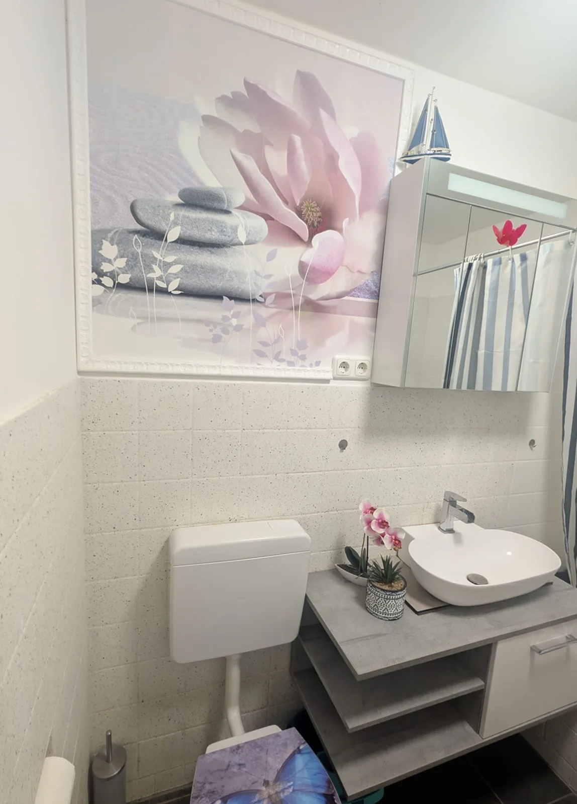 Badezimmer nach der Badsanierung mit modernem Waschplatz und dekorativer Wandgestaltung