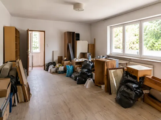 Entrümpelung einer Wohnung mit ausgeräumten Möbeln, Kartons und Müllsäcken