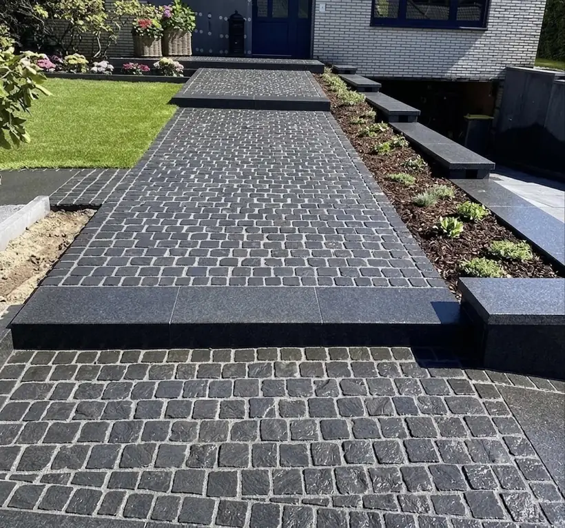 Gepflasterter Gartenweg mit Stufen und bepflanztem Randbereich als moderne Außenanlage