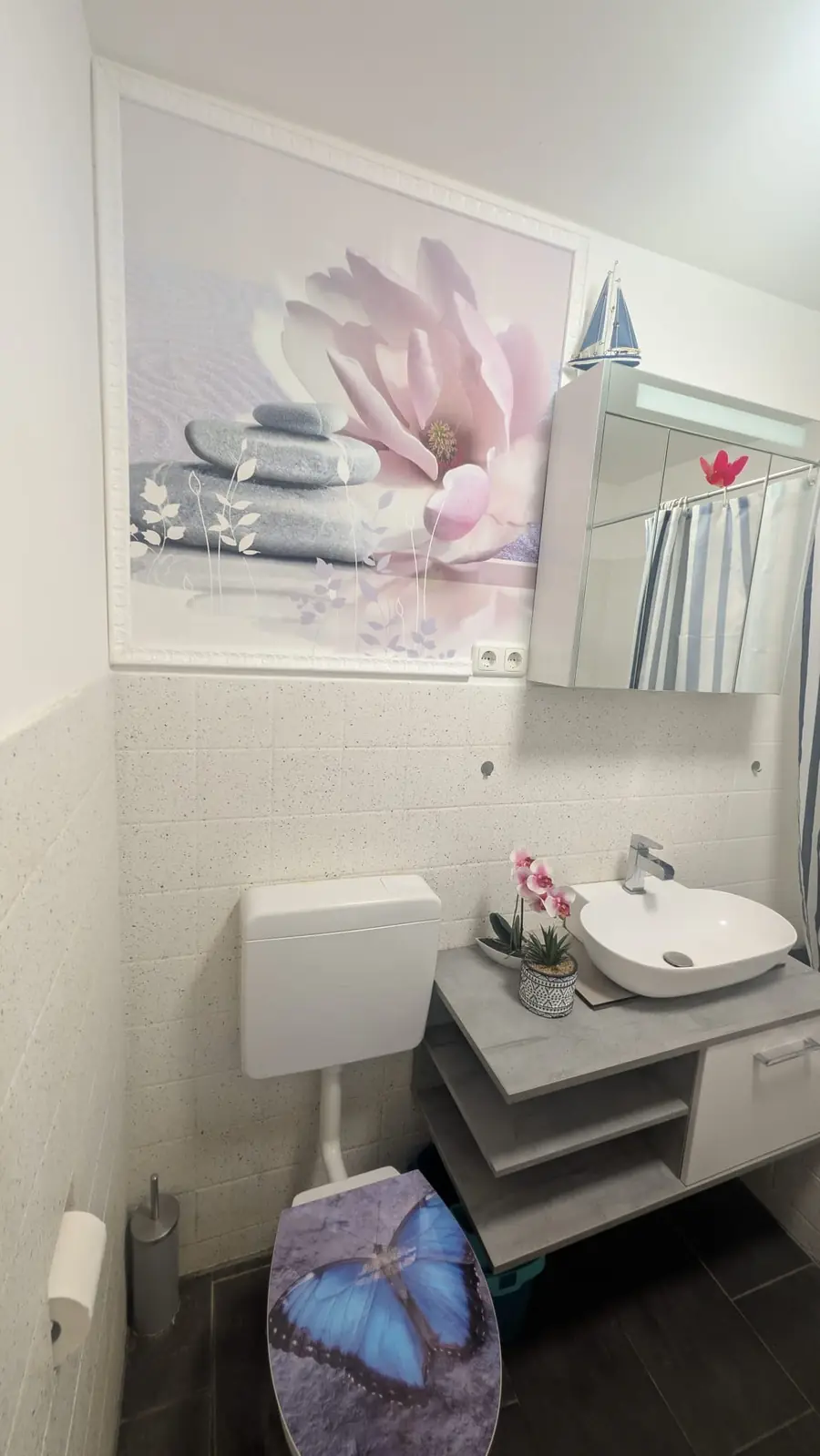 Modernes Gäste-WC mit Waschtisch, hellen Wandfliesen und dekorativer Fototapete über dem WC.